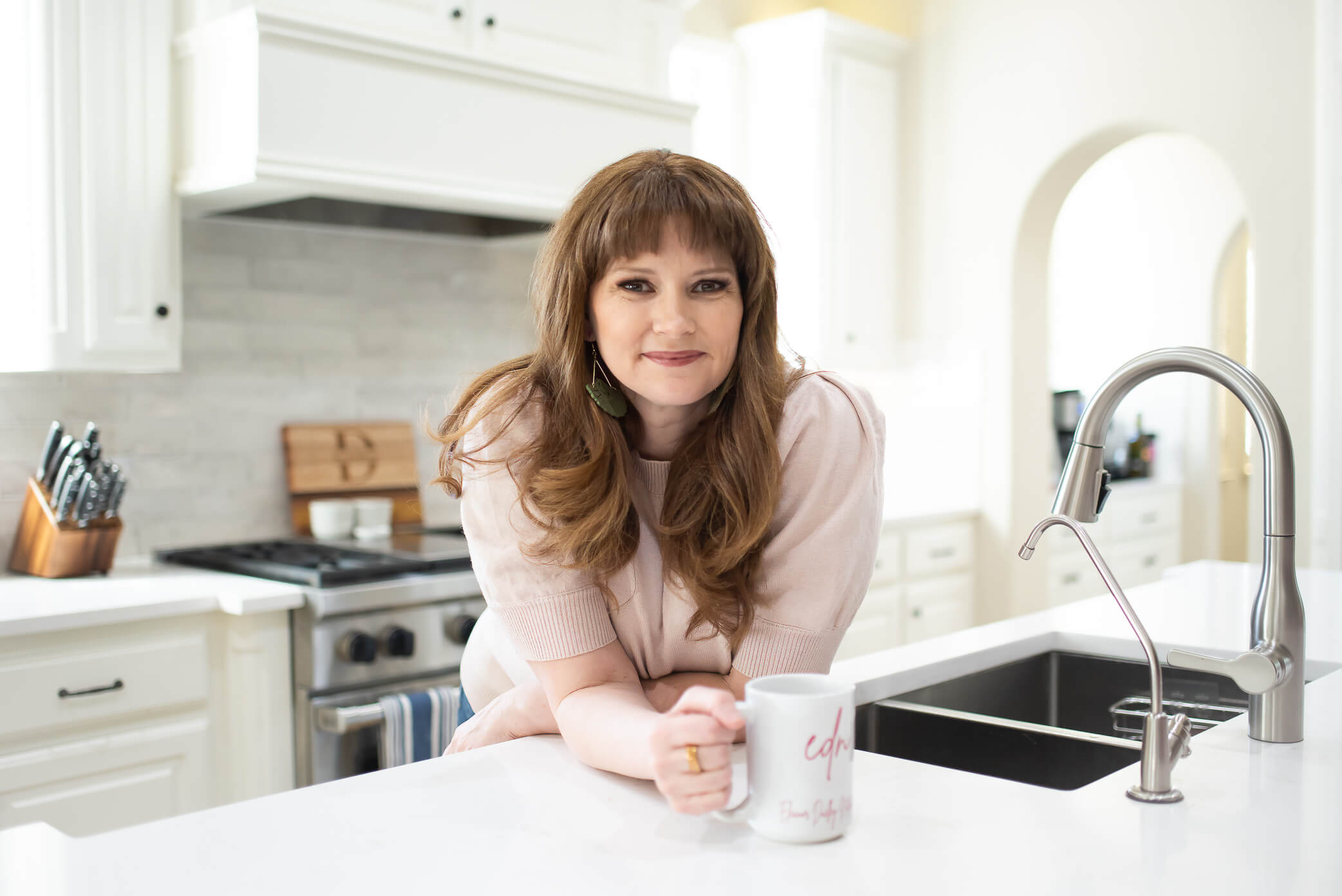business owner in her kitchen with branded coffee mug