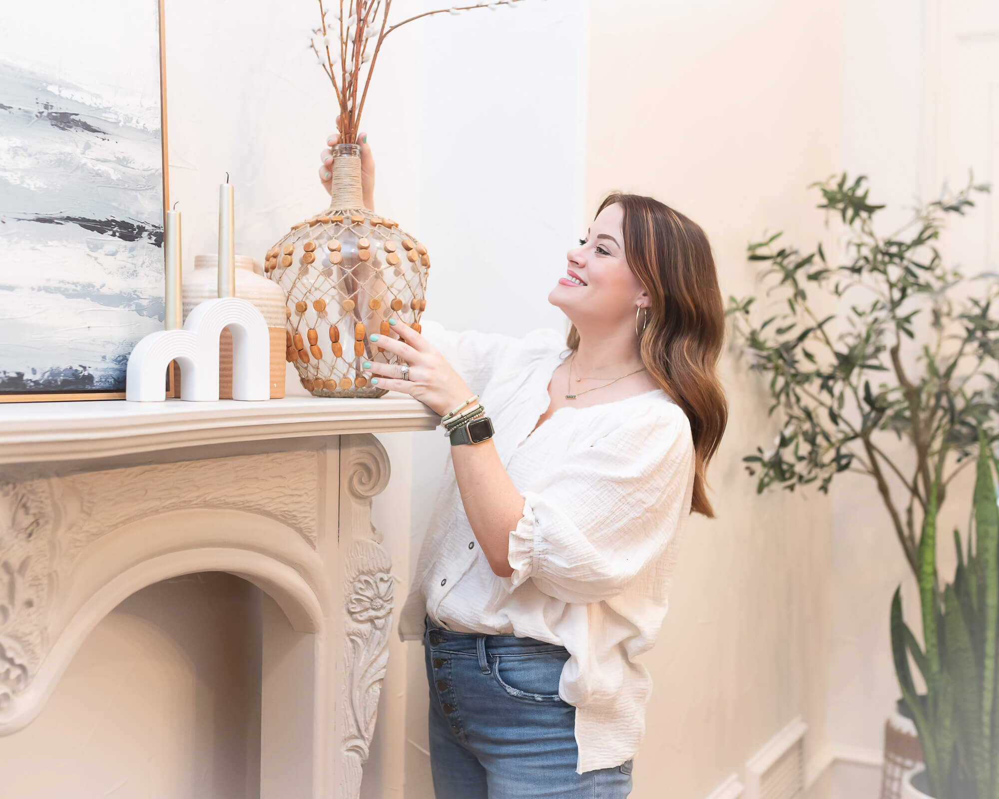 woman adding a vase to a mantle in a branding photogrpahy session for an interior design company