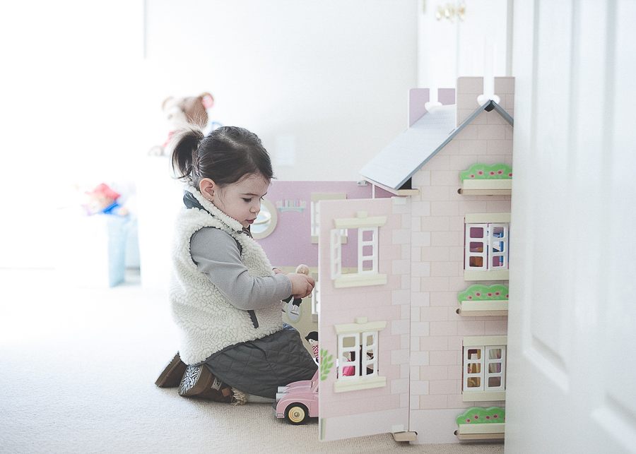 little girl playing with a doll house