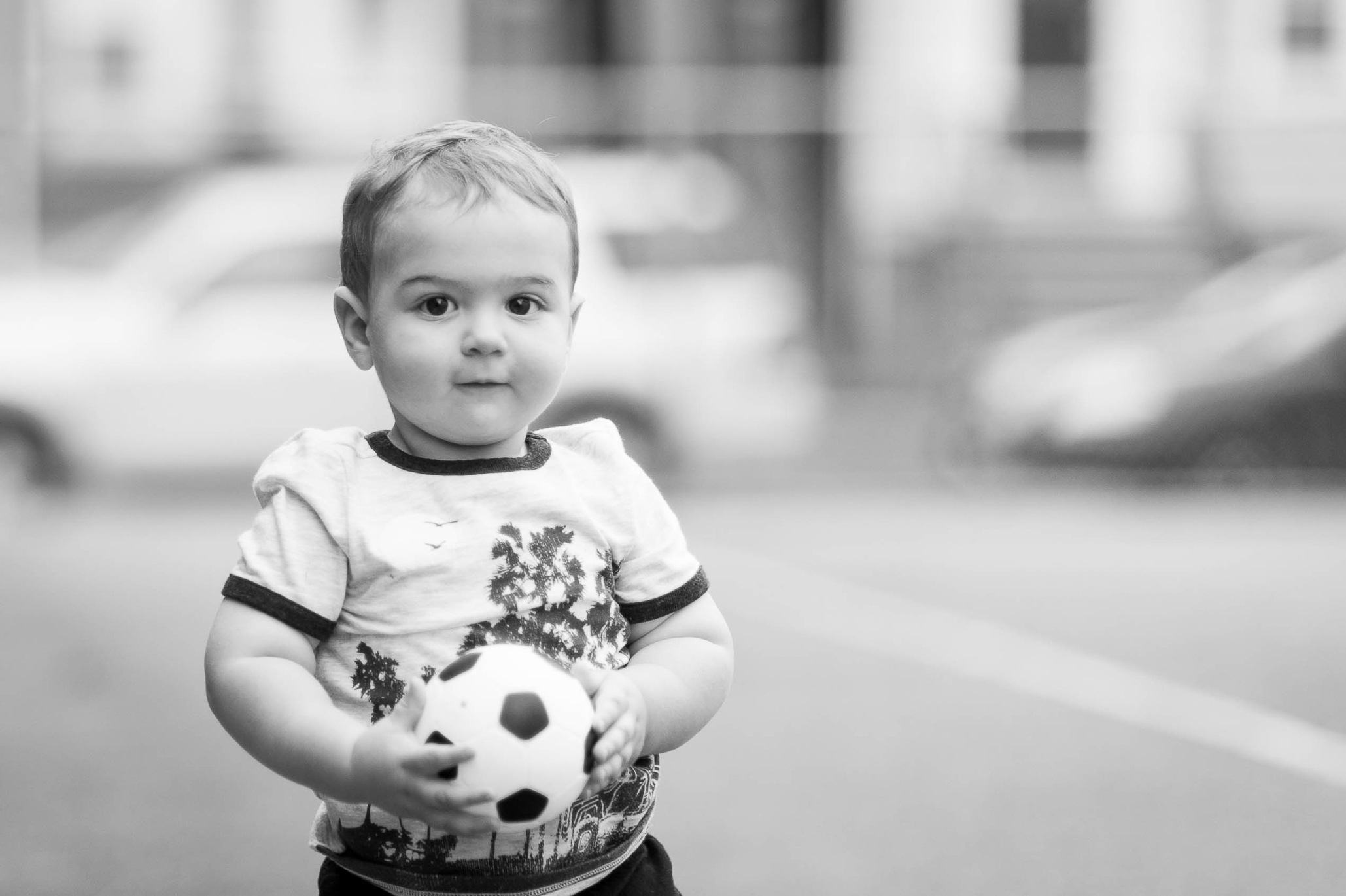 black & white photo of a toddler boy with a soccer ball