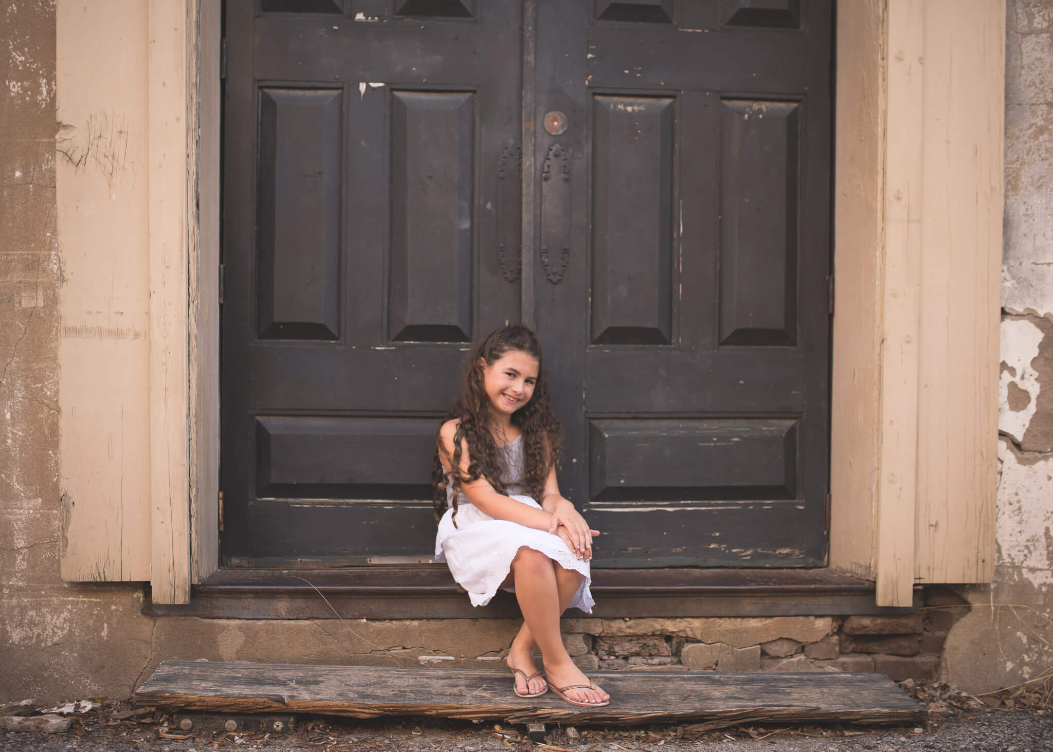 young girl sitting in doorway in Downtown McKinney