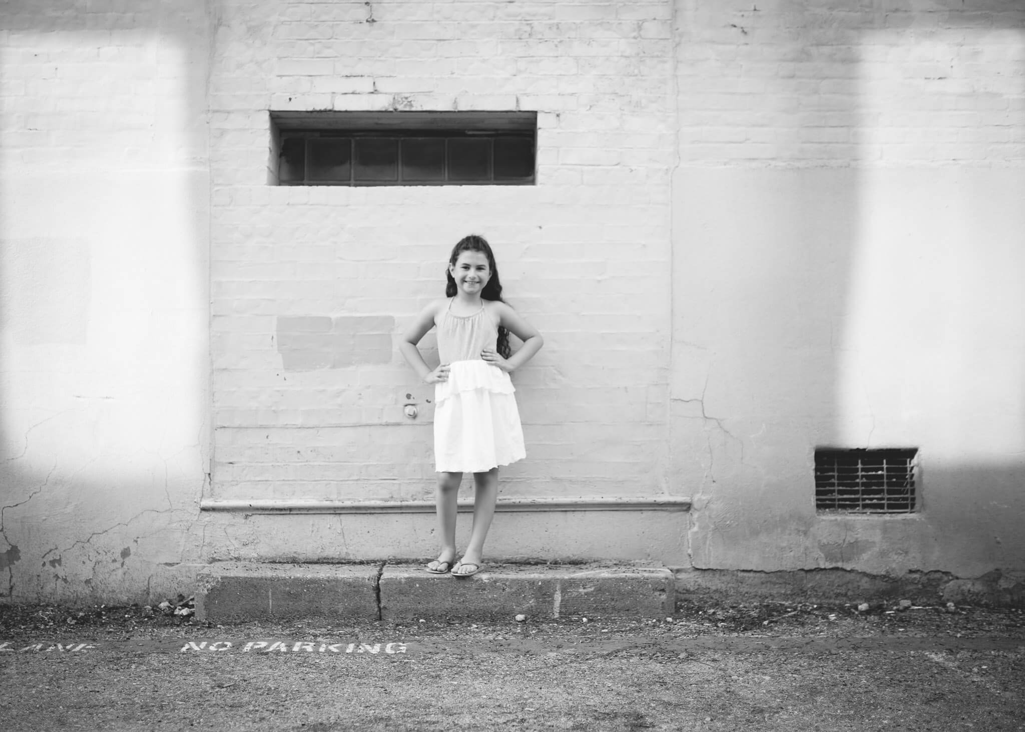 Black and white downtown photo of girl on step