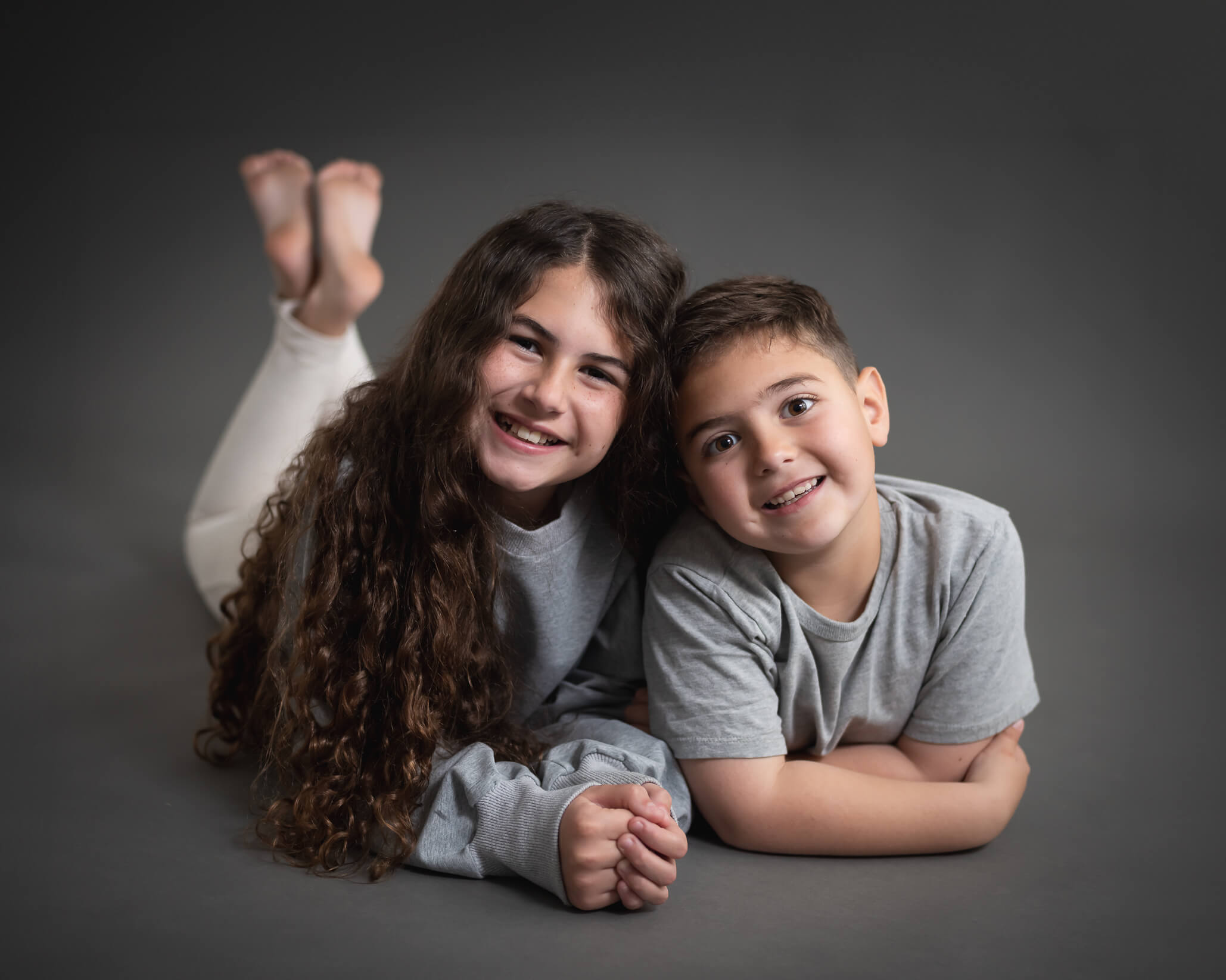 kiddos laying together for a sibling studio photo session