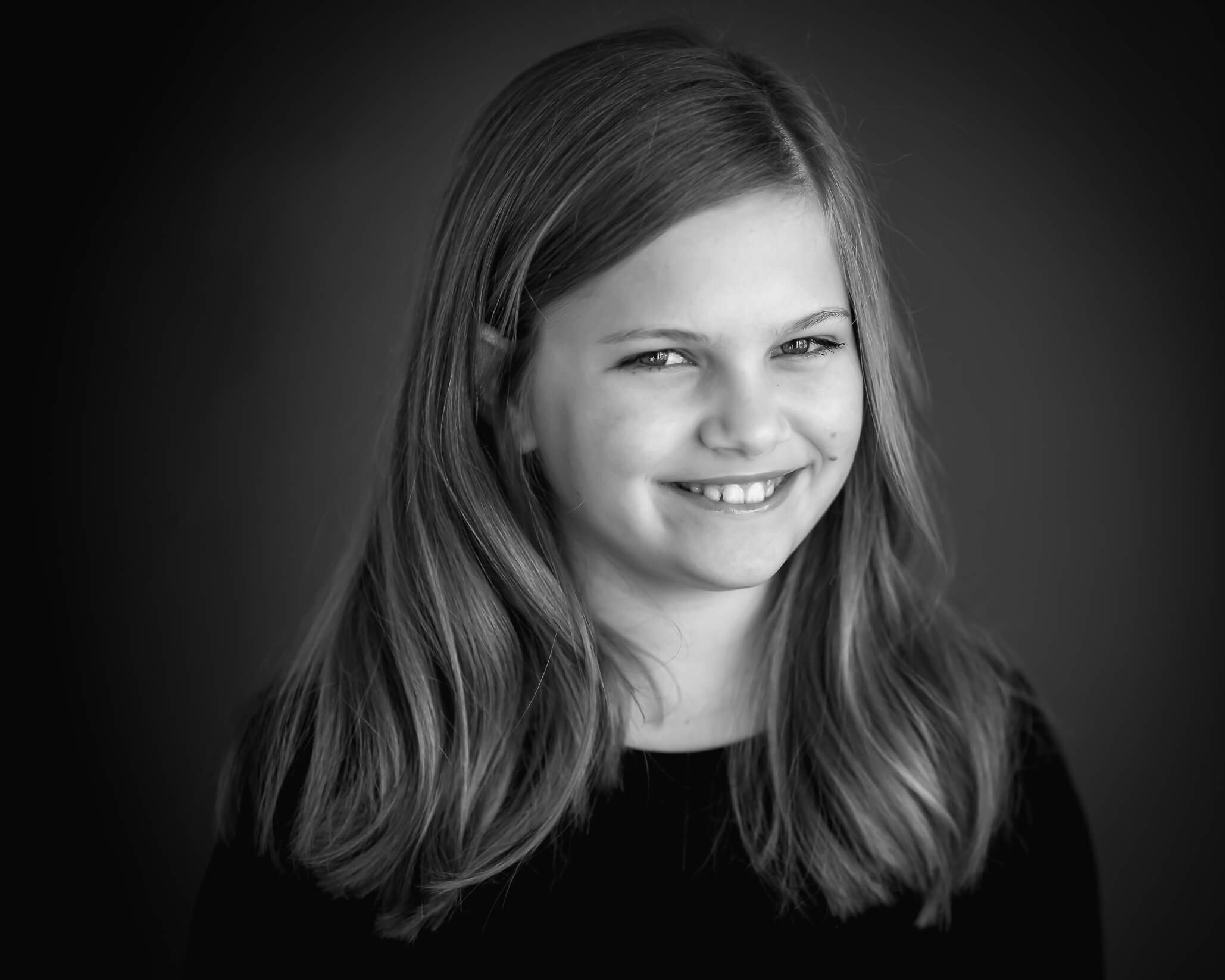 10 year old girl in black and white studio session with mischievous grin