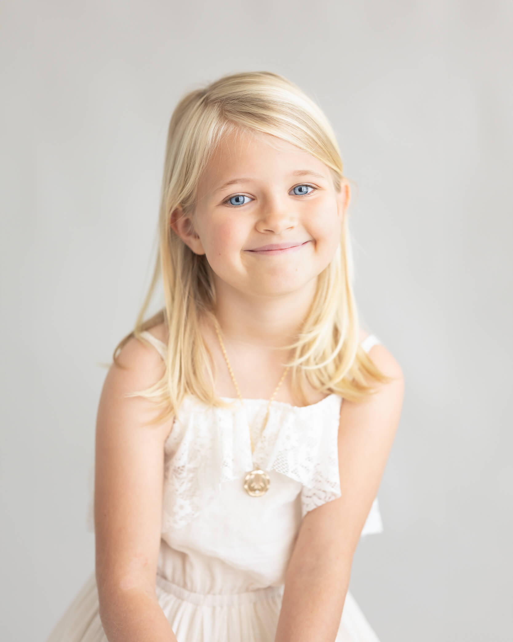 beautiful child in off-white dress studio portrait light and airy captured by Allison Amores Photography