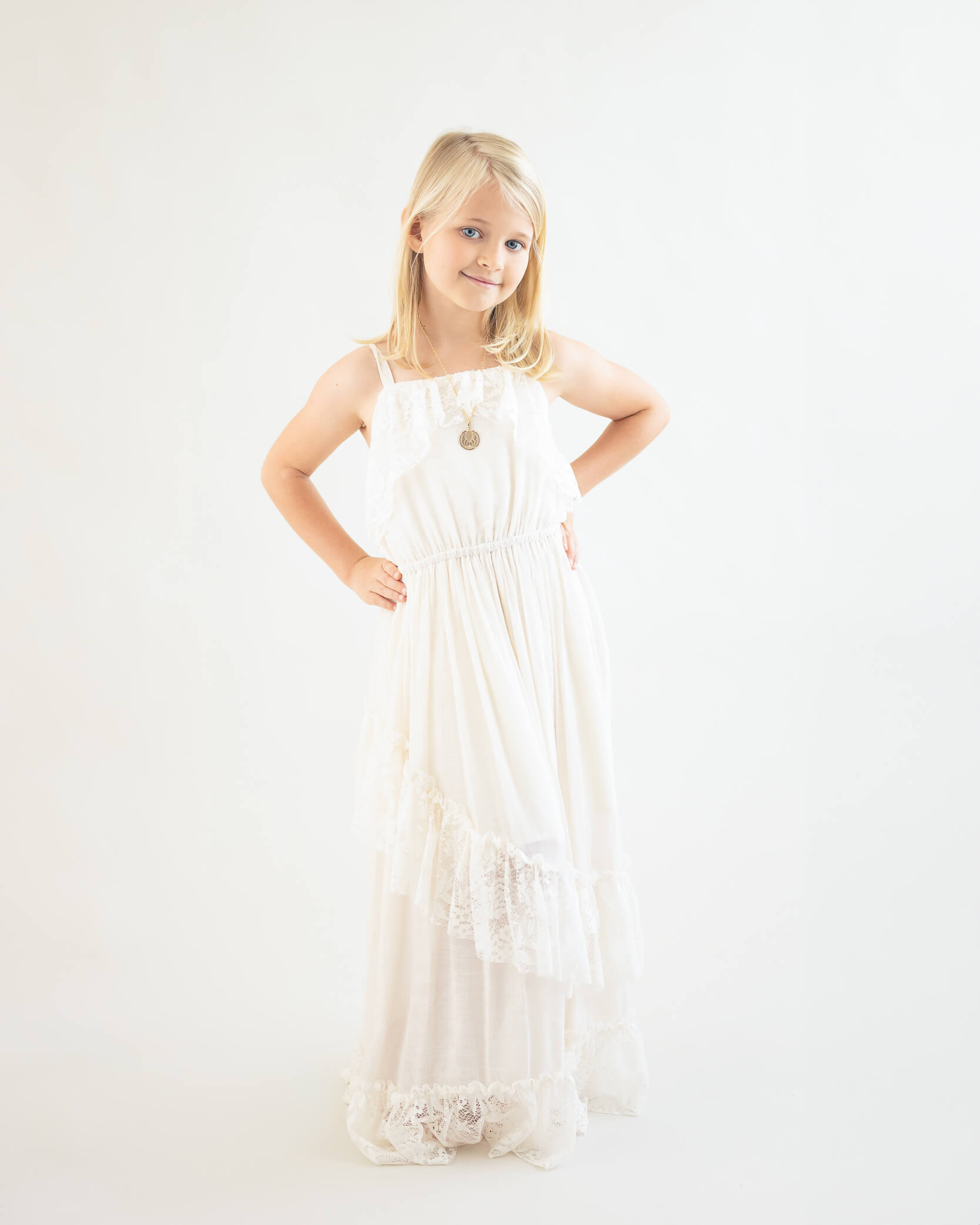 beautiful girl in off-white long flowy dress on an off-white background for her Children's portraits captured by Allison Amores Photography