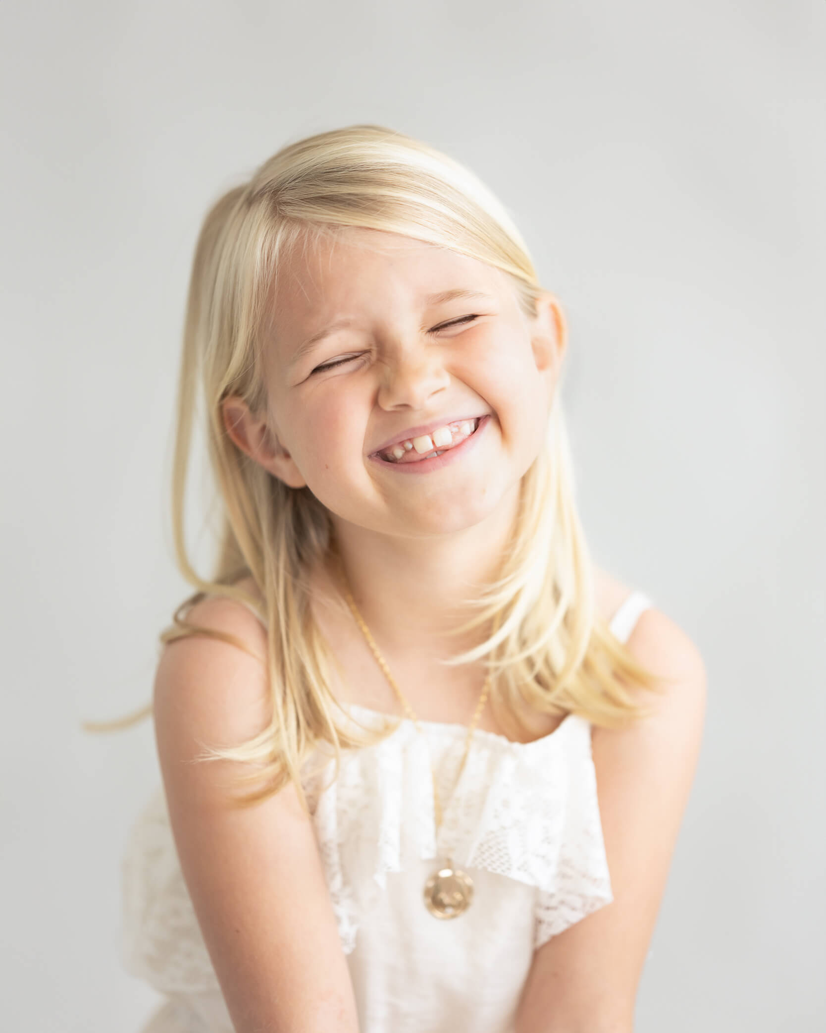 silly personality portrait of young girl laughing in studio