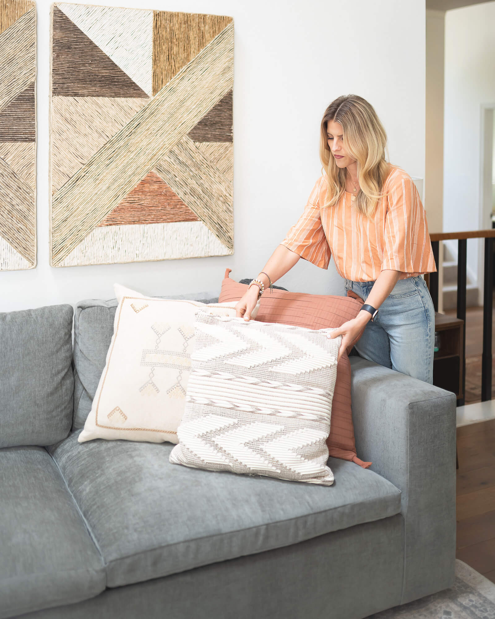 business owner adding throw pillows to a sofa in her branding photo shoot