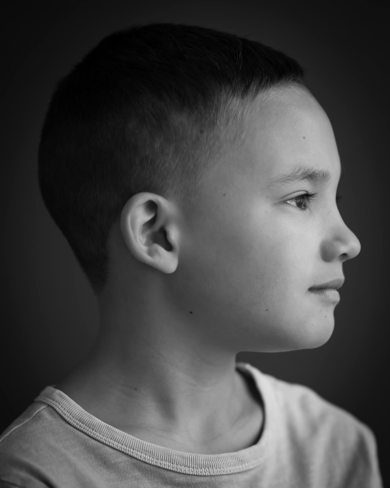 Profile portrait of boy in B&W, studio portrait dramamtic