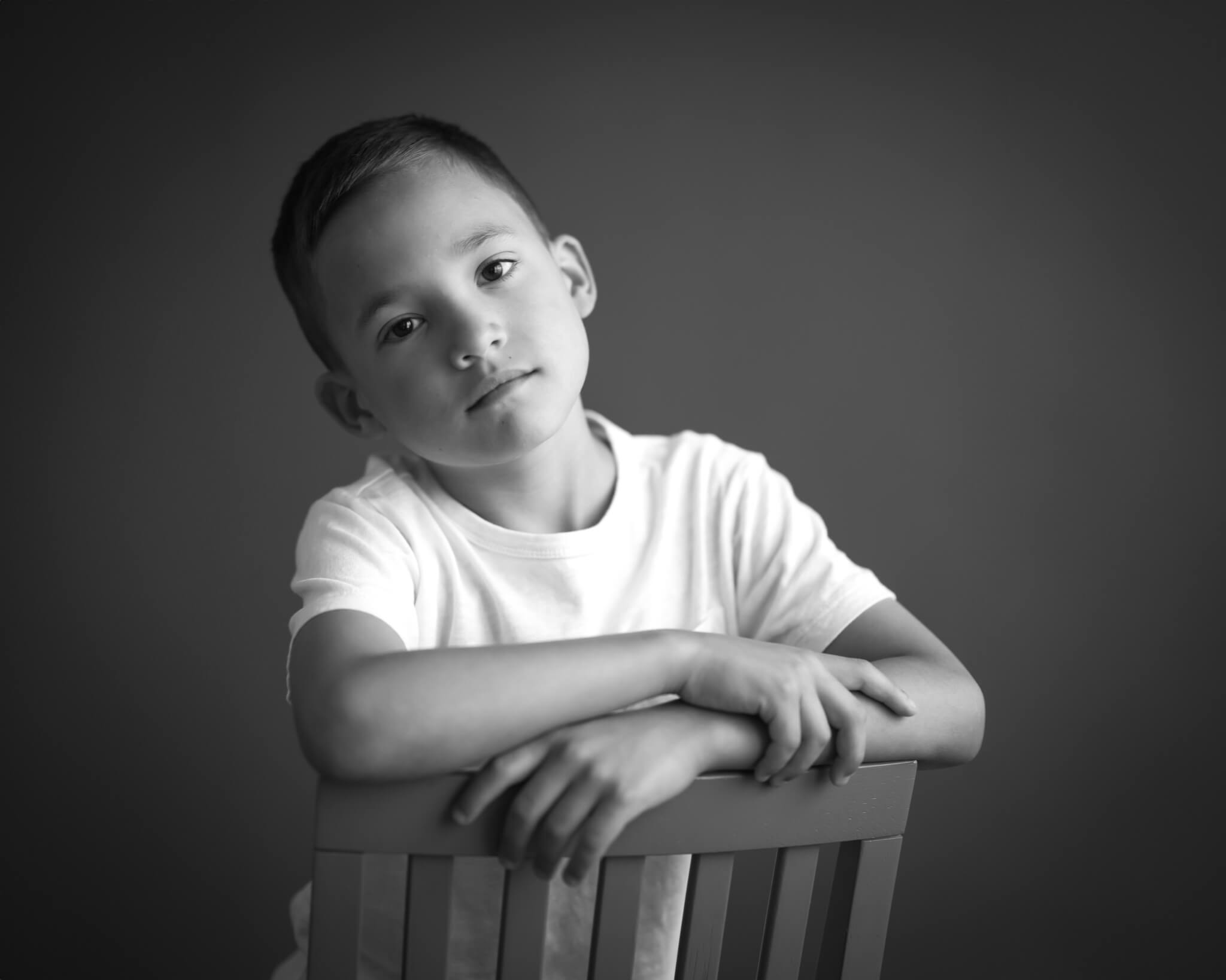 dramatic B&W portrait of boy in studio captured by Allison Amores Photography