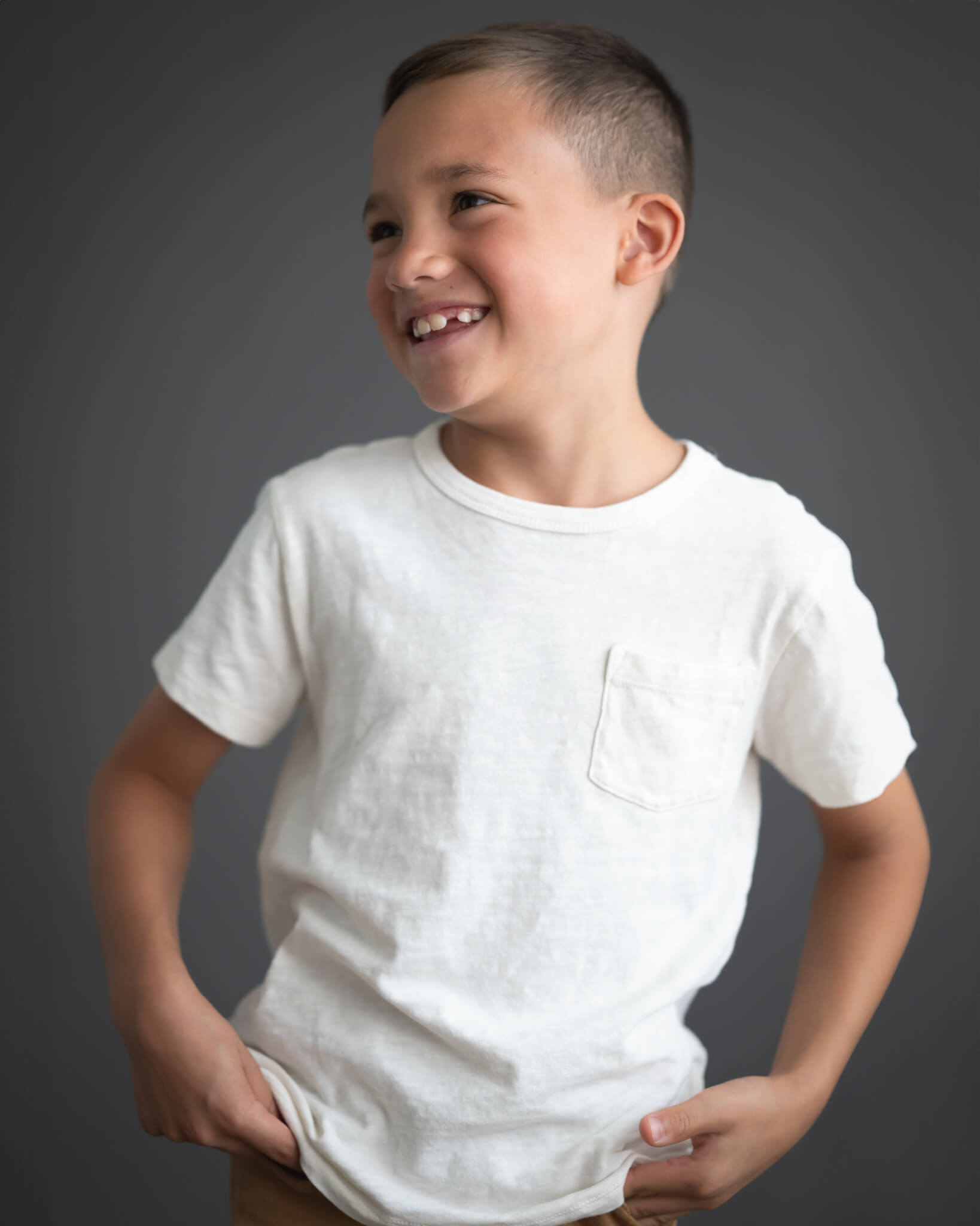 Cutest boy in white tee shirt portrait with dark background