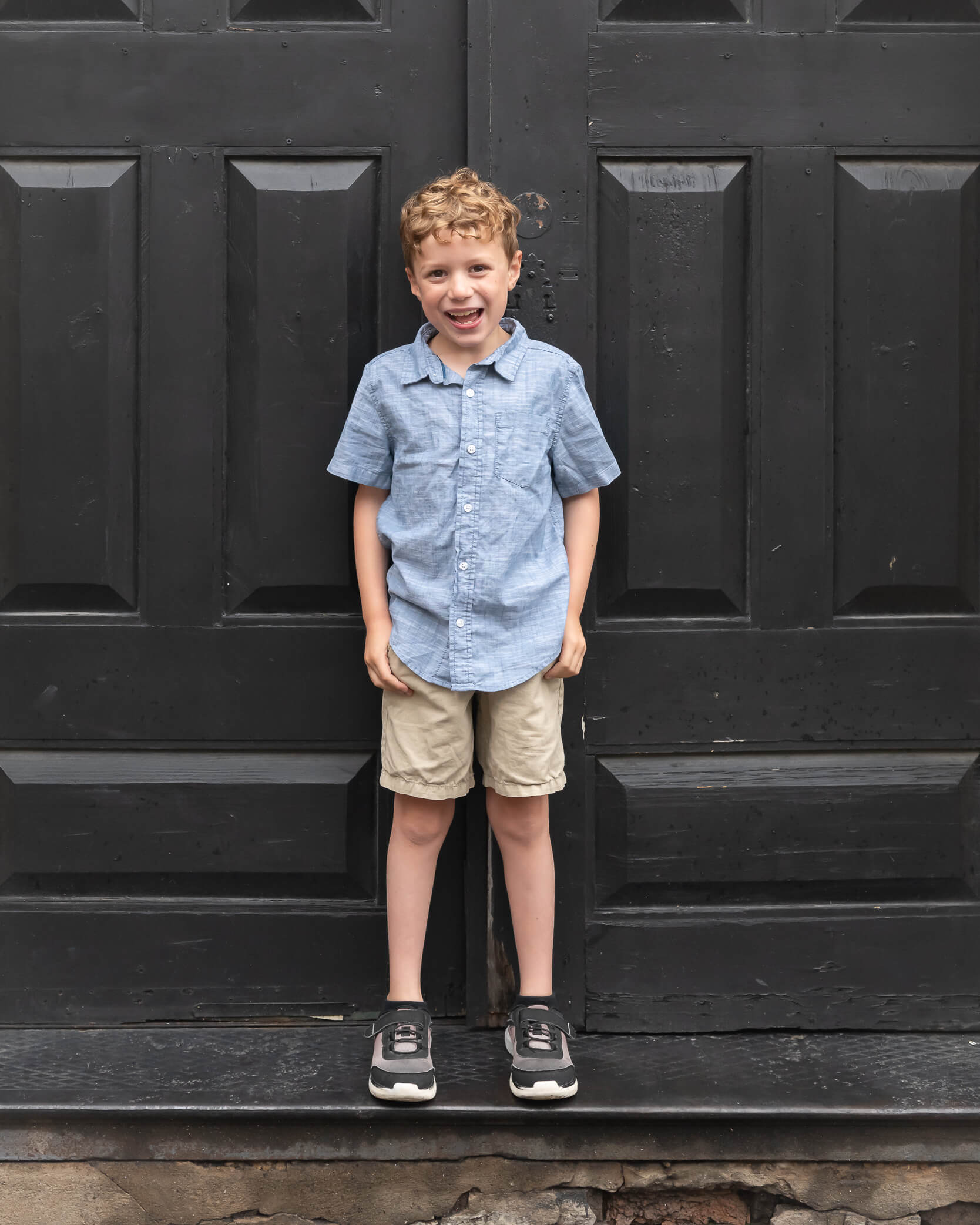 Cutest little boy in front of black door in Downtown McKinney Family session photo