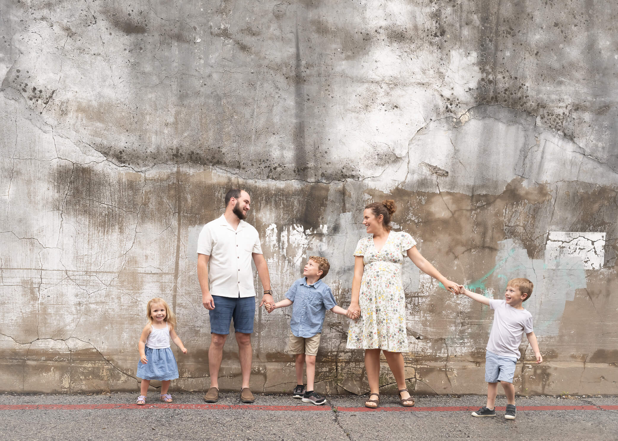 family of 5 with 3 littles next to mural wall 