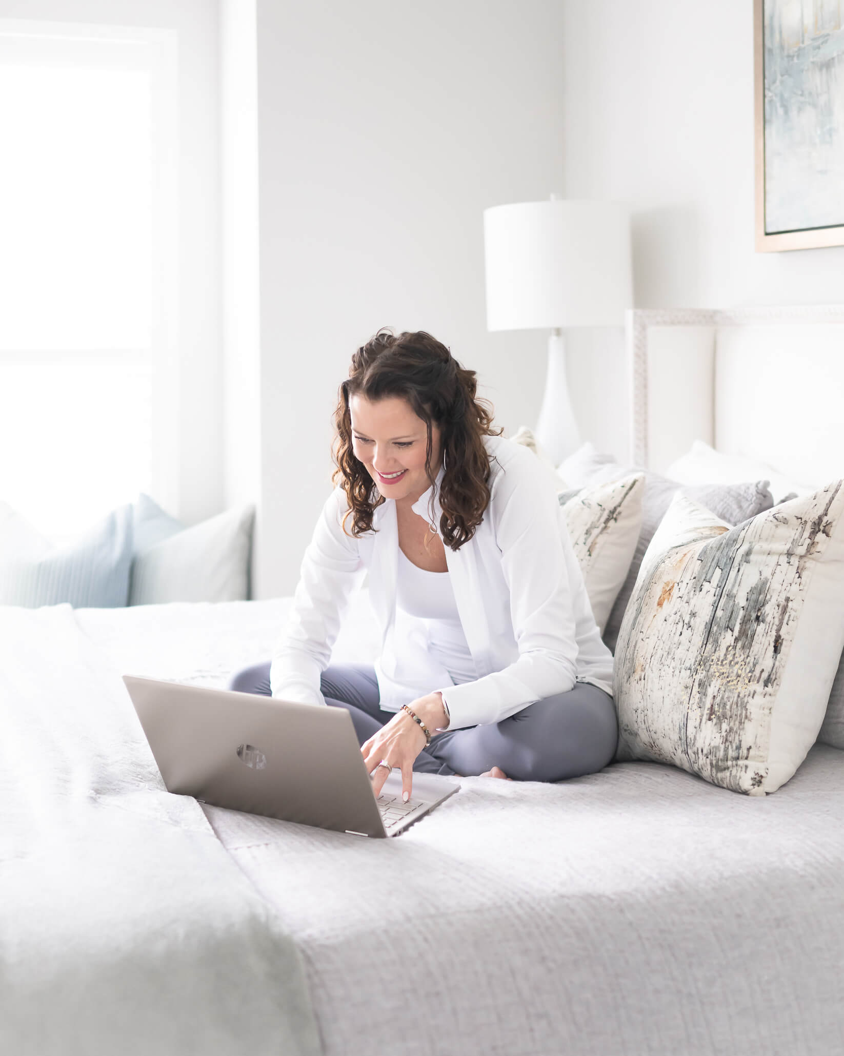 Health coach in athletic wear working on laptop in her bedroom