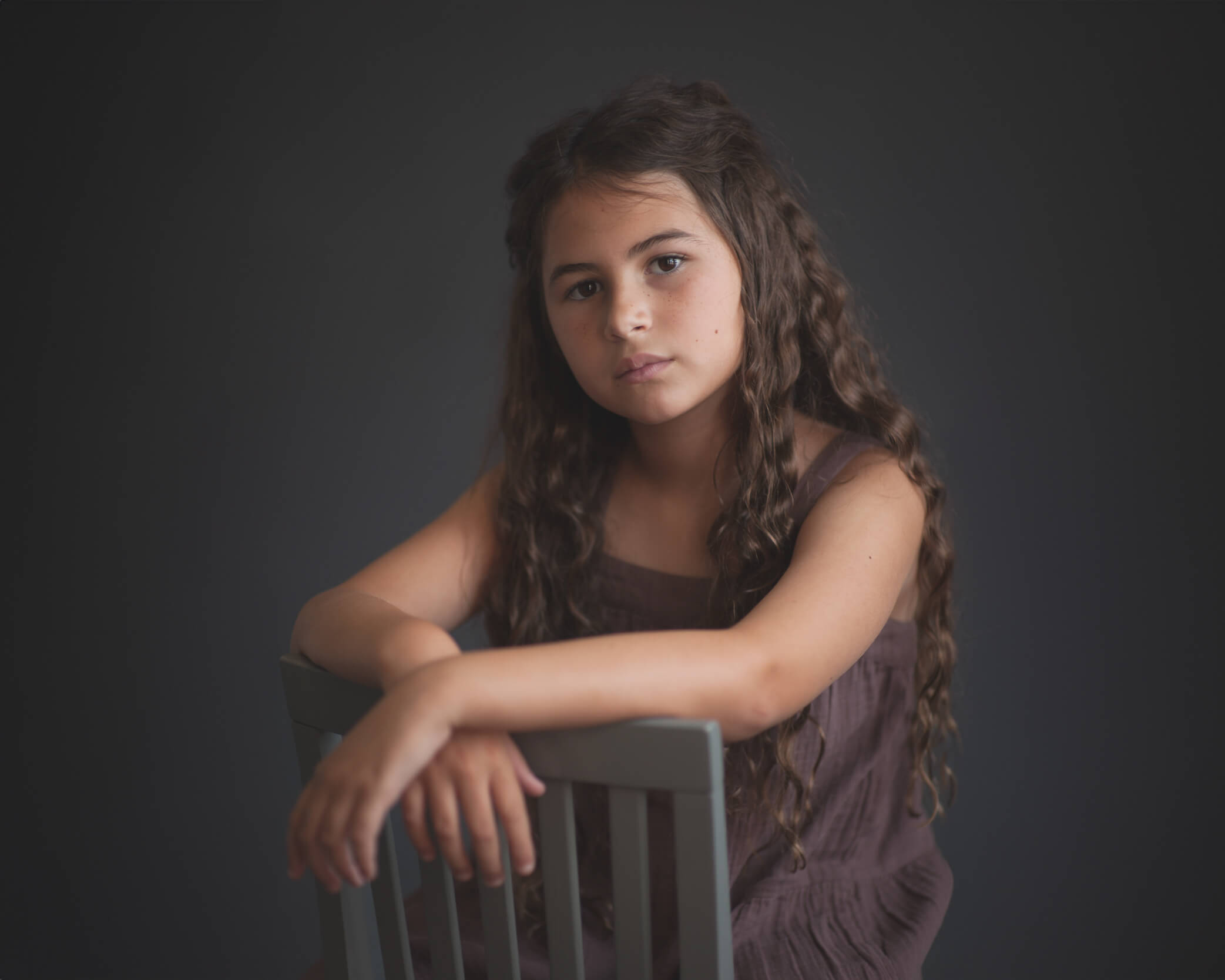 beautiful timeless studio portrait of girl in brown dress against grey backdrop captured by Allison Amores Photography