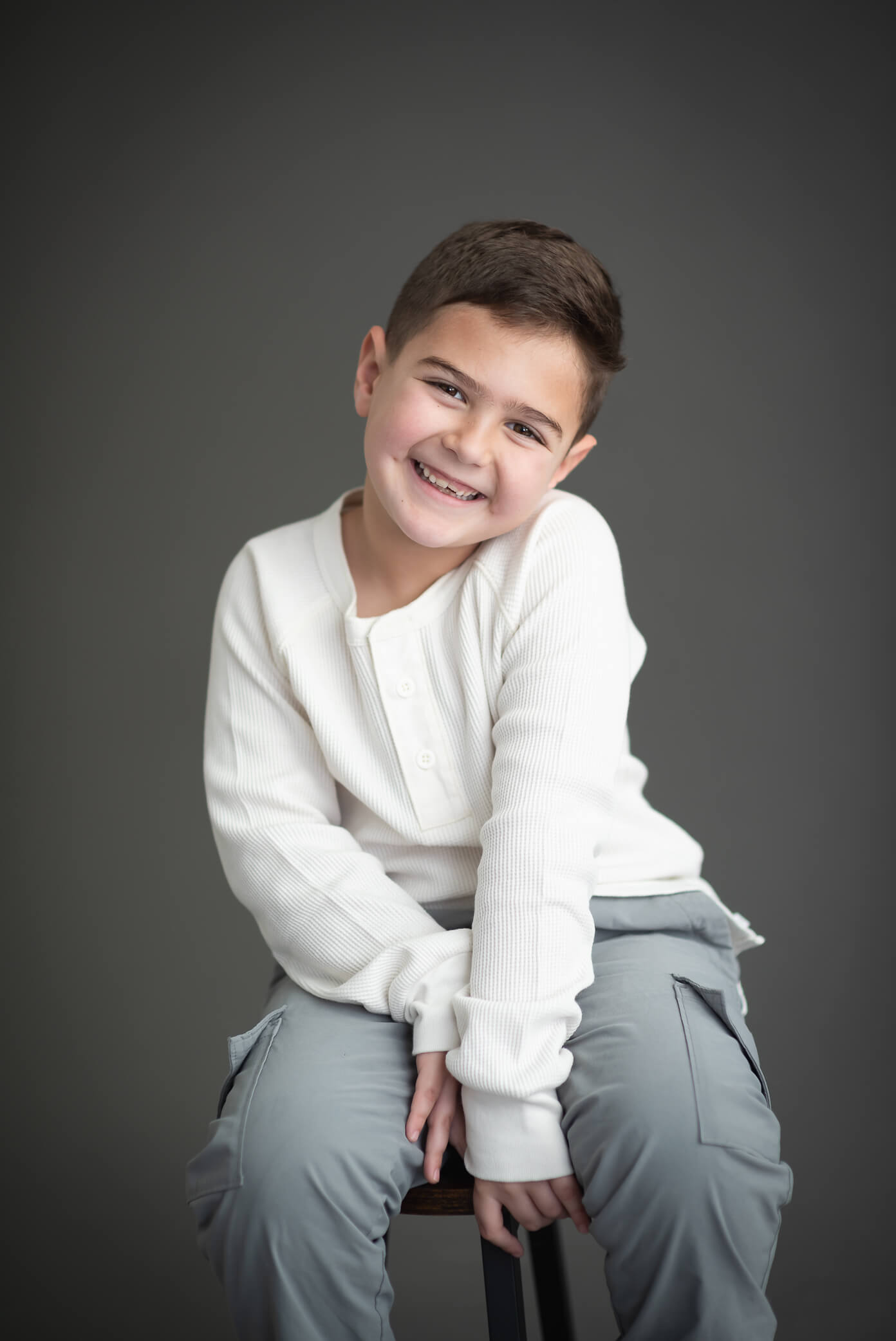 adorable 6 year old boy with missing teeth looking so cute in a studio photo session