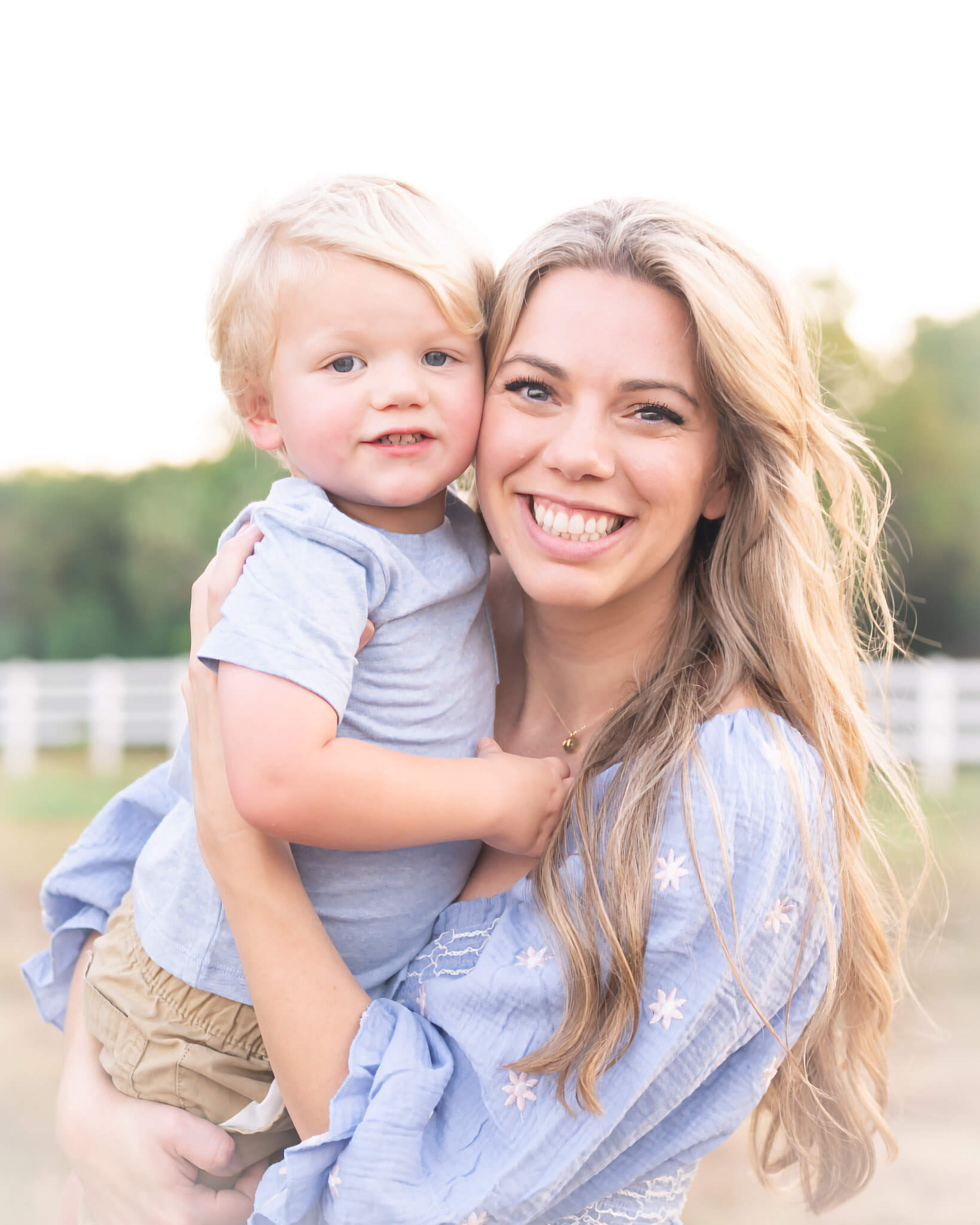 Beautiful mom and toddler son with blonde hair wearing light blue and tan in light and airy family mini session photo at Erwin Park captured by Allison Amores Photography