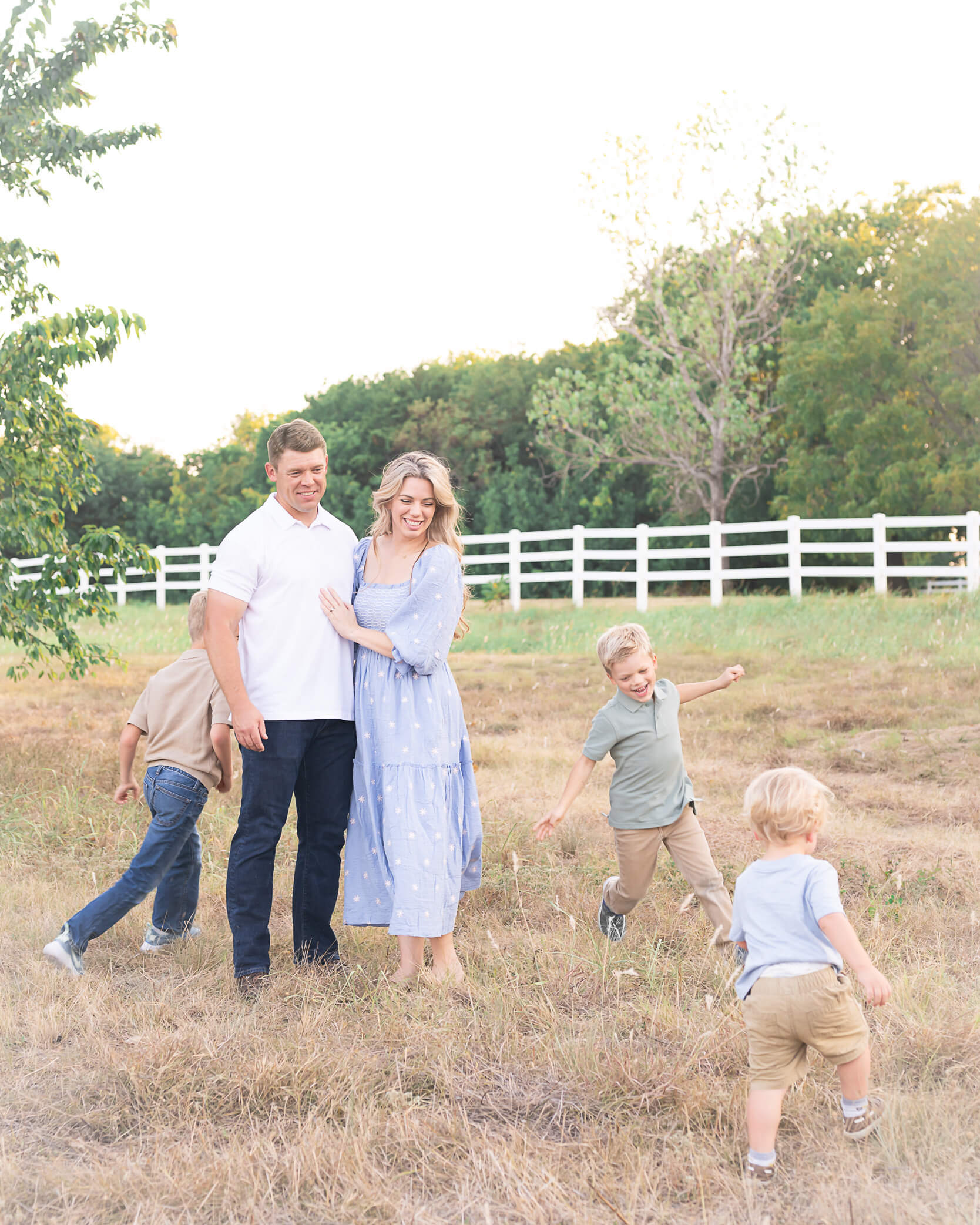 Beautiful family with 3 little boys all dressed in light cool tones playing around in Erwin park during Allison Amores Photography's Fall 2024 Family Mini Sessions