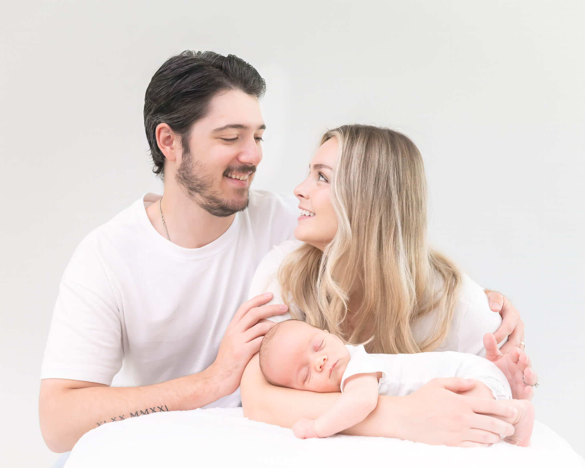 new dad and mom with tiny sleeping baby