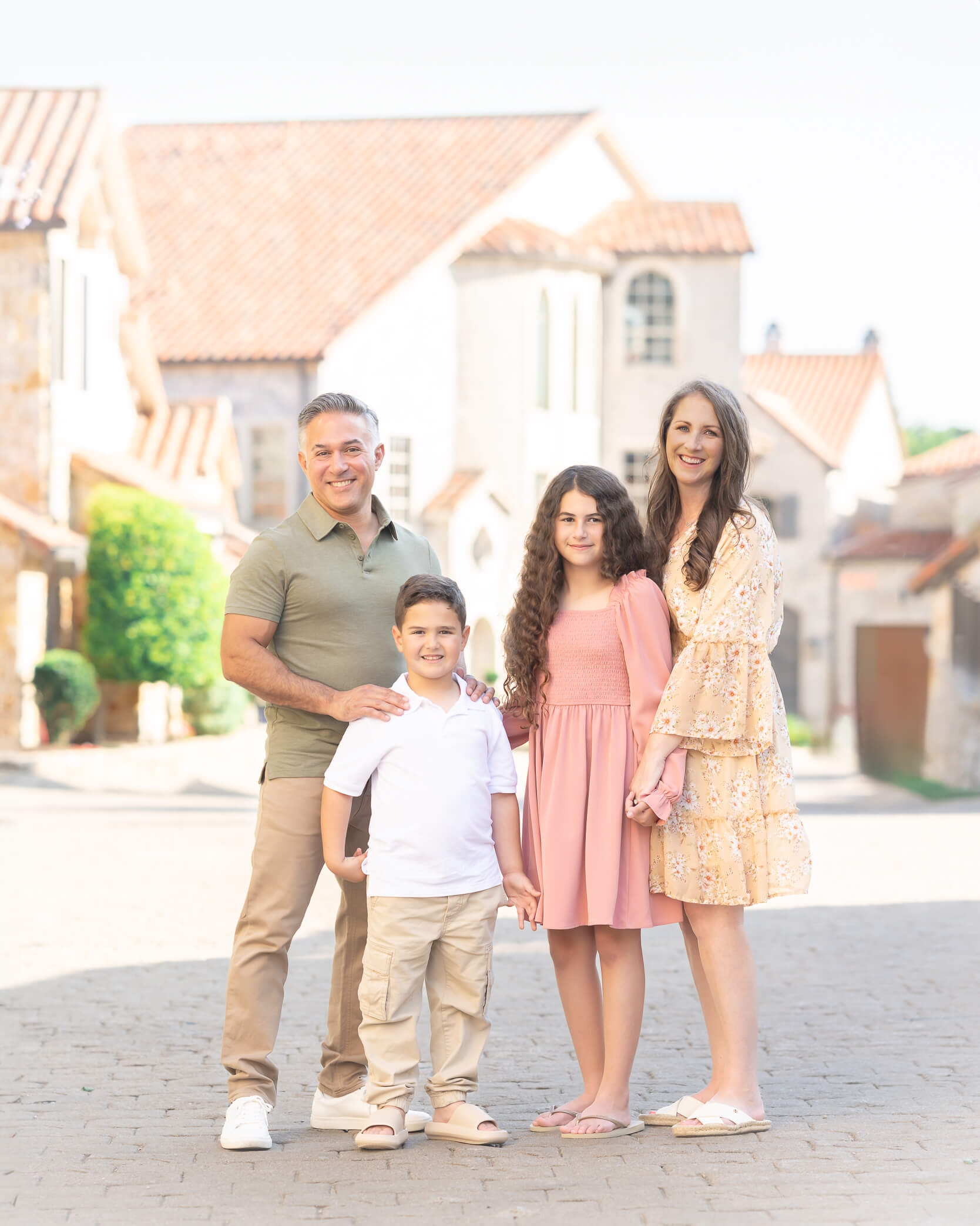 Family dressed in peach pink sage and white in Adriatica Village in McKinney tx
