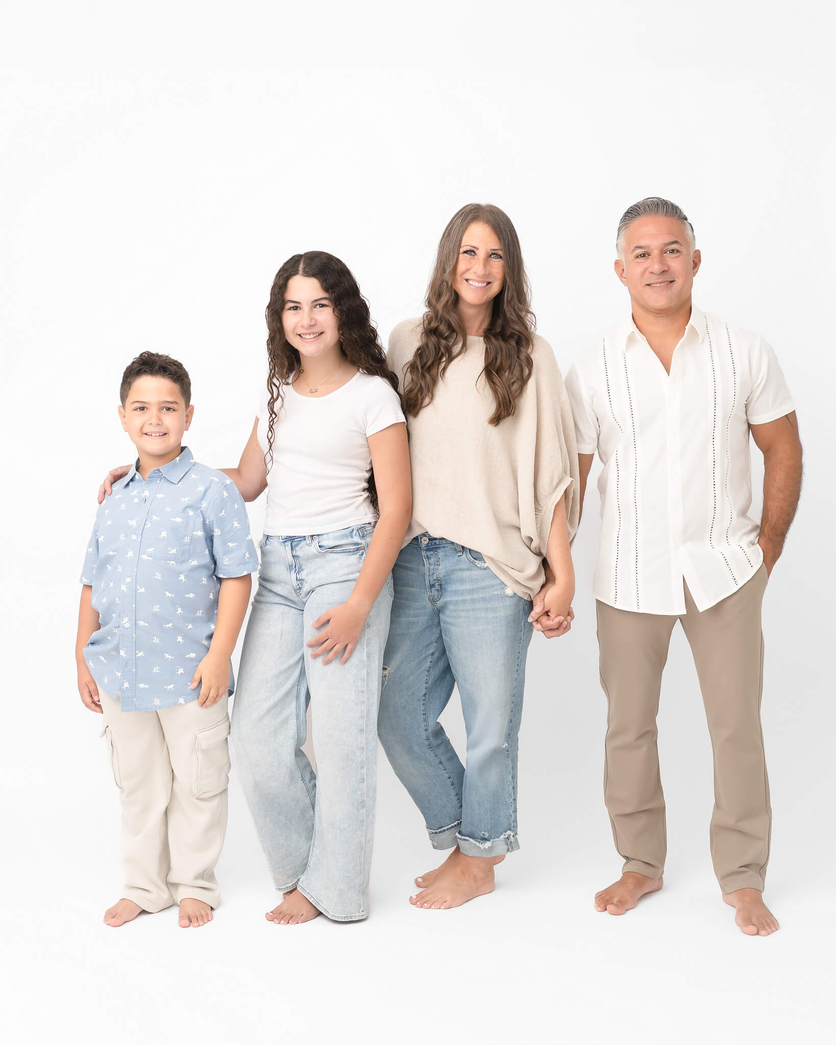 Family in neutrals and denim in fun white studio session